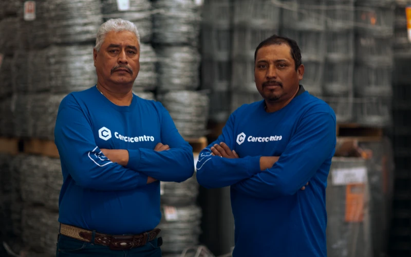 Equipo de CC enfrente a rollos de alambres apilados